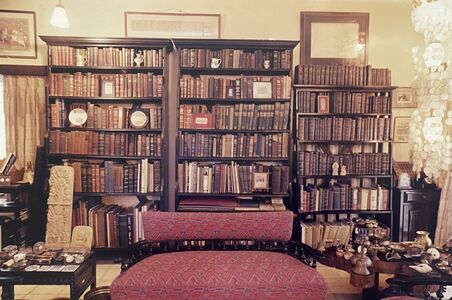 Awesome collection of books juxtaposed by antiques and prints.